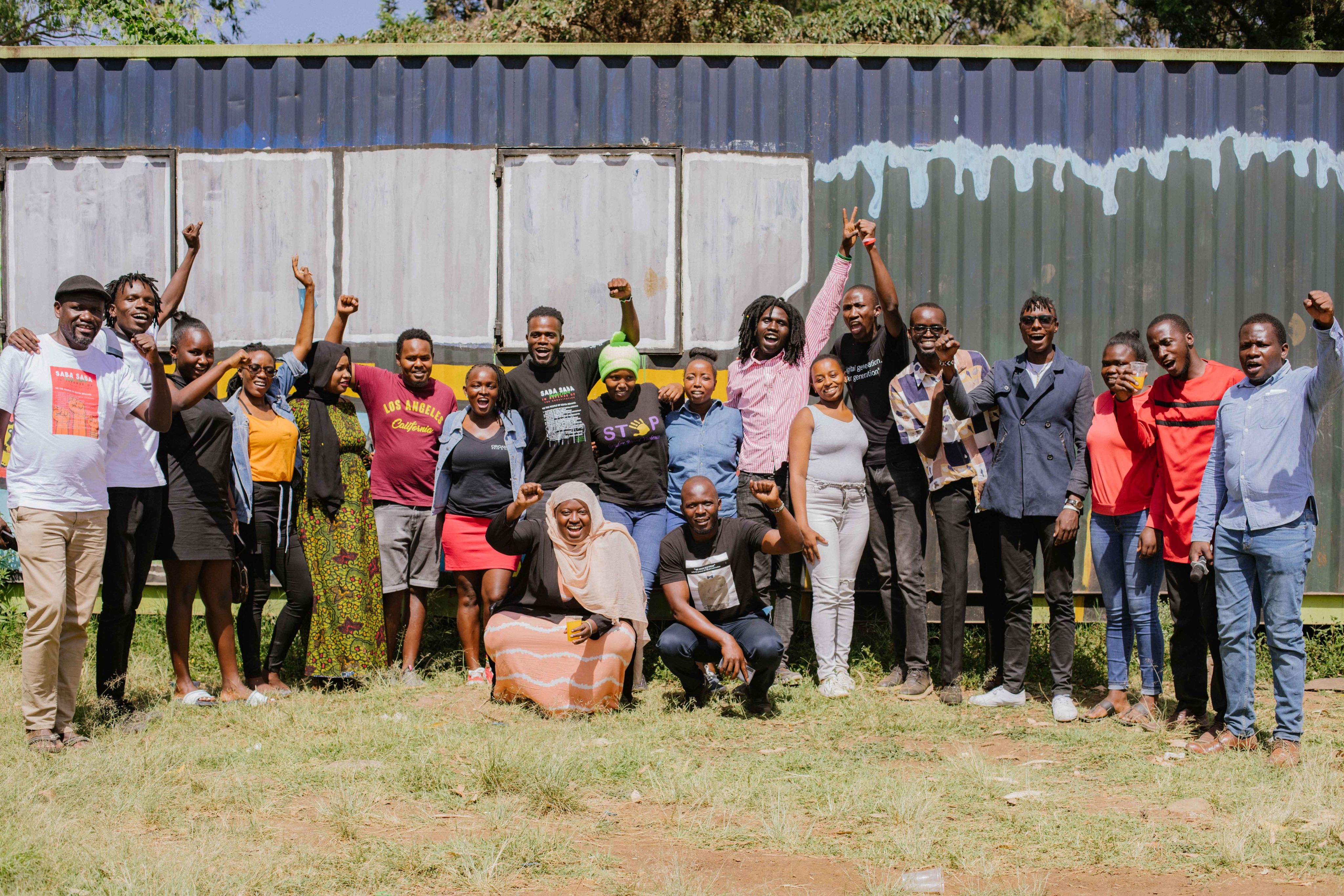 A group of some of the event participants smiling and waving.